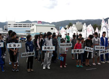 プラカードを掲げ並ぶ選手たち