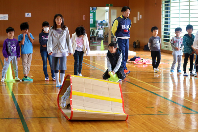 輪っか状にした段ボールの中に入って、転がしながら進む様子