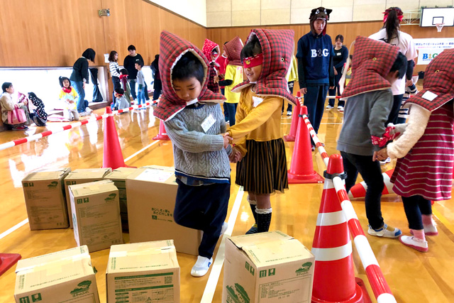 体育館の中で、たくさんの段ボールなどを障害物に見立てて避難