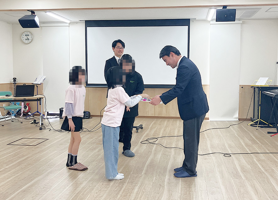  
											子どもたちからお礼の言葉と色紙が贈呈された