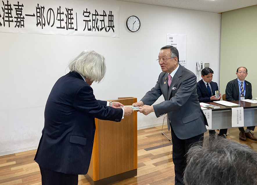 完成した偉人マンガを斎藤委員長から高木市長へ