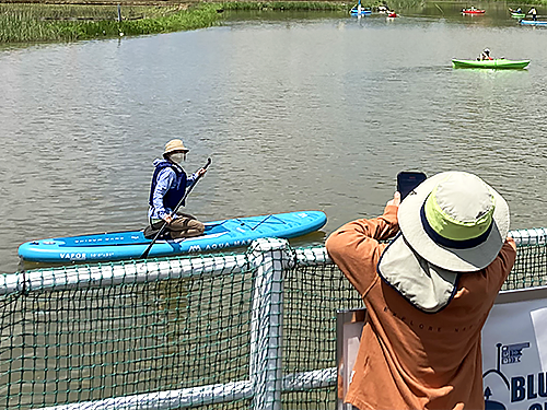 SUPに乗ったお母さんをお子さんが岸からパチリ