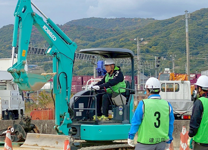 三木町重機研修で研修参加者が協力して重機操作の作業手順を確認している様子