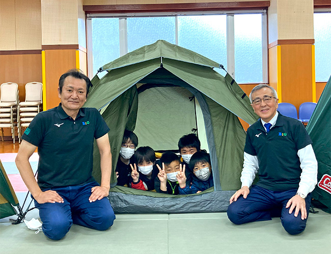 菅原理事長（左）とテントで楽しむ子ども達、奥塚市長（右）