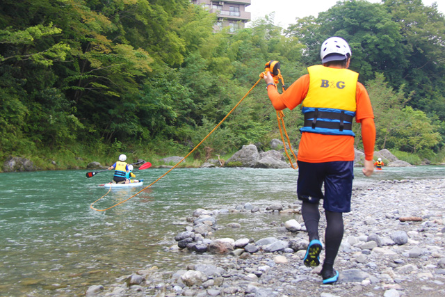 SUPの後ろにロープをつけて、流れにのまれなようにスタッフが岸辺でしっかりと握ってついていきます