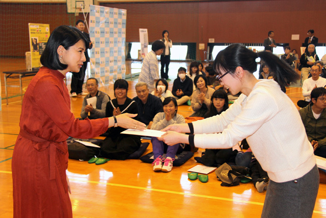 中江さんから色紙を手渡されている参加者の女の子