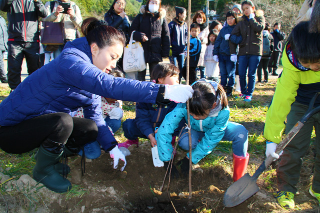 子どもたちと一緒に植える酒井さん