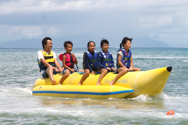 バナナボートに乗って海を走る子供たち