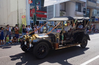 市内をパレードする超クラシックな自動車。乗っている人たちは皆、ご満悦の様子です