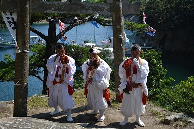 「奇祭」の神事を執り行う大島神社の神主の方々。風待ちの入り江が背後に控えています