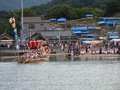 最終目的地の宮の浜をめざして力漕する「皇子丸」。陸地では、到着を待って大勢の人が詰めかけています