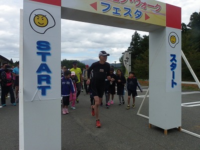 元気にスタートする参加者の皆さん。ちょっと雲に隠れていますが、遠くに雄大な鳥海山が控えています