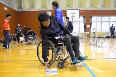 車いすに乗り、物を拾うのもなかなか大変…