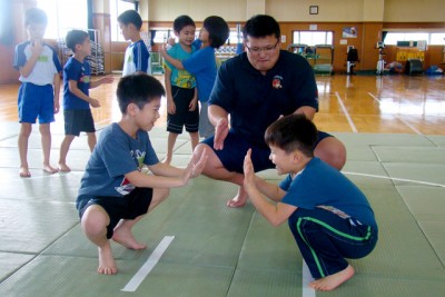 相撲を取る前に、蹲踞（そんきょ）の姿勢で手押し相撲