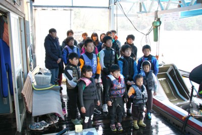 あいにくの豪雨の中、桟橋の屋根の下での開会式に参加する子供たちの様子