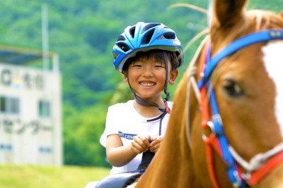 乗馬を楽しむ少年。極上の笑顔がまぶしい。