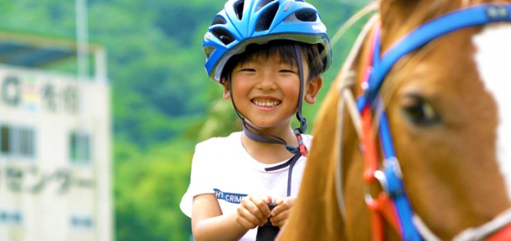 乗馬を楽しむ少年。極上の笑顔がまぶしい。