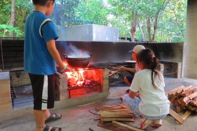 薪をかまどにくべている子どもたち。どのくらいの火加減がいいのかなあ…