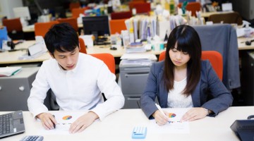 誰もいないくなったオフィスで残業する男女の画像