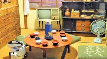 昭和70年代の家庭の写真。和室、丸いちゃぶ台に座布団、ブラウン管テレビ。