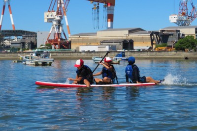 SUPに3人で乗って体験中の男の子たち