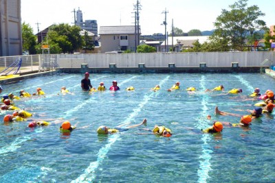 ライフジャケットを着て、円形に浮かぶ子供たち