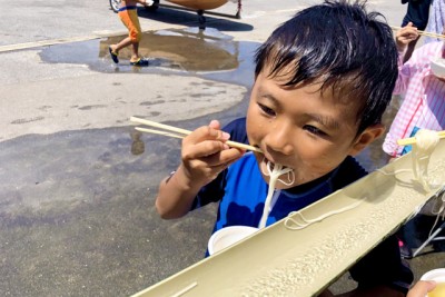 流しそうめんを食べる男の子