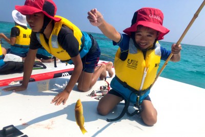 みごと魚を釣り上げ、満面の笑みがこぼれる男の子