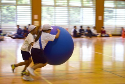 女の子と男の子の二人が大きなボールをもって疾走中！