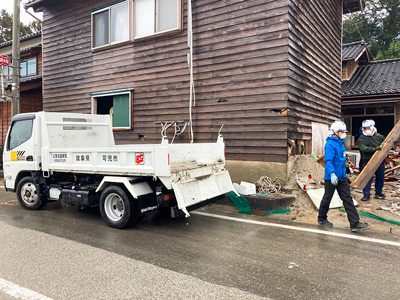 能登町にて災害ボランティアが瓦礫をダンプに運ぶ様子