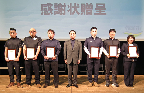 全国指導者会 工藤会長（中央）と、表彰を受ける退任ブロック責任者6名