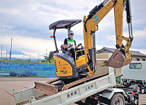 ダンプへの重機の積み込み