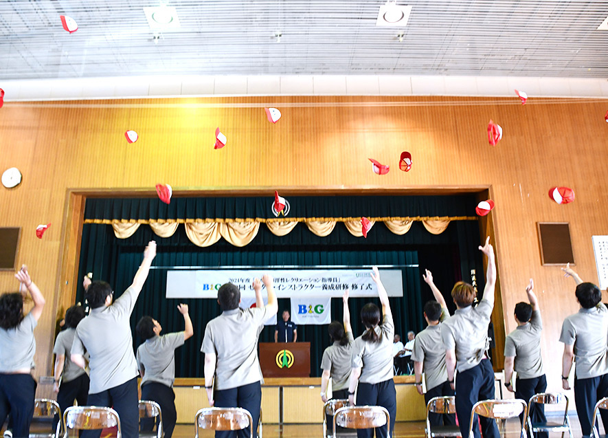 修了式で帽子を一斉に投げる研修生たち