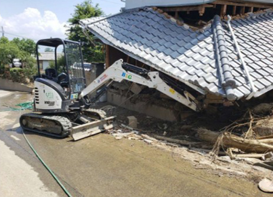 倒壊家屋のがれきを取り除く重機