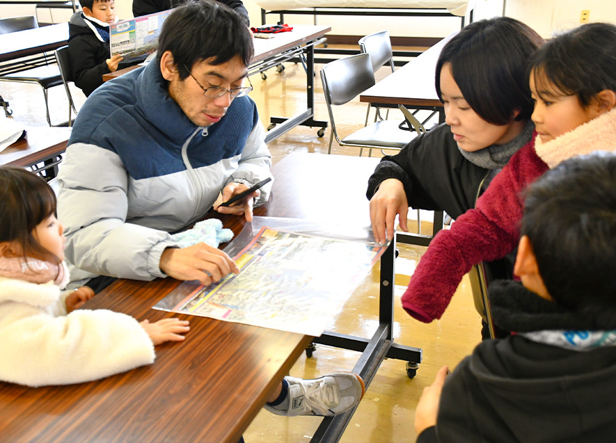 地図を囲み、真剣な表情で作戦を練るファミリー